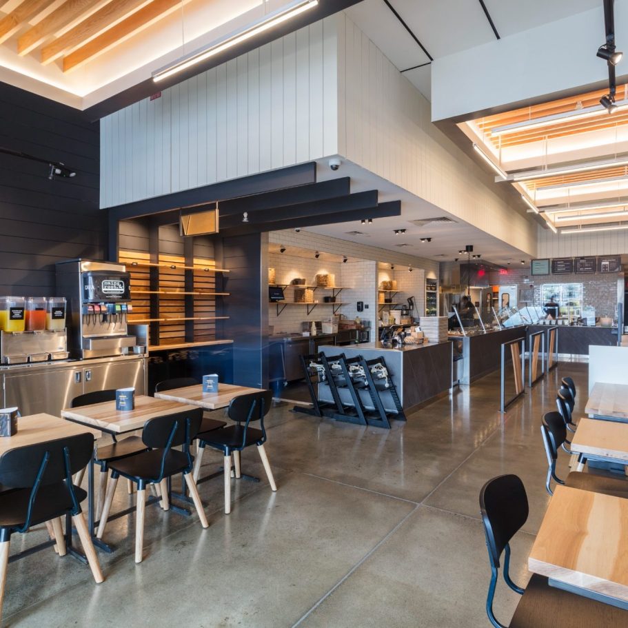 Modern restaurant interior with wooden tables and a sleek, open layout.